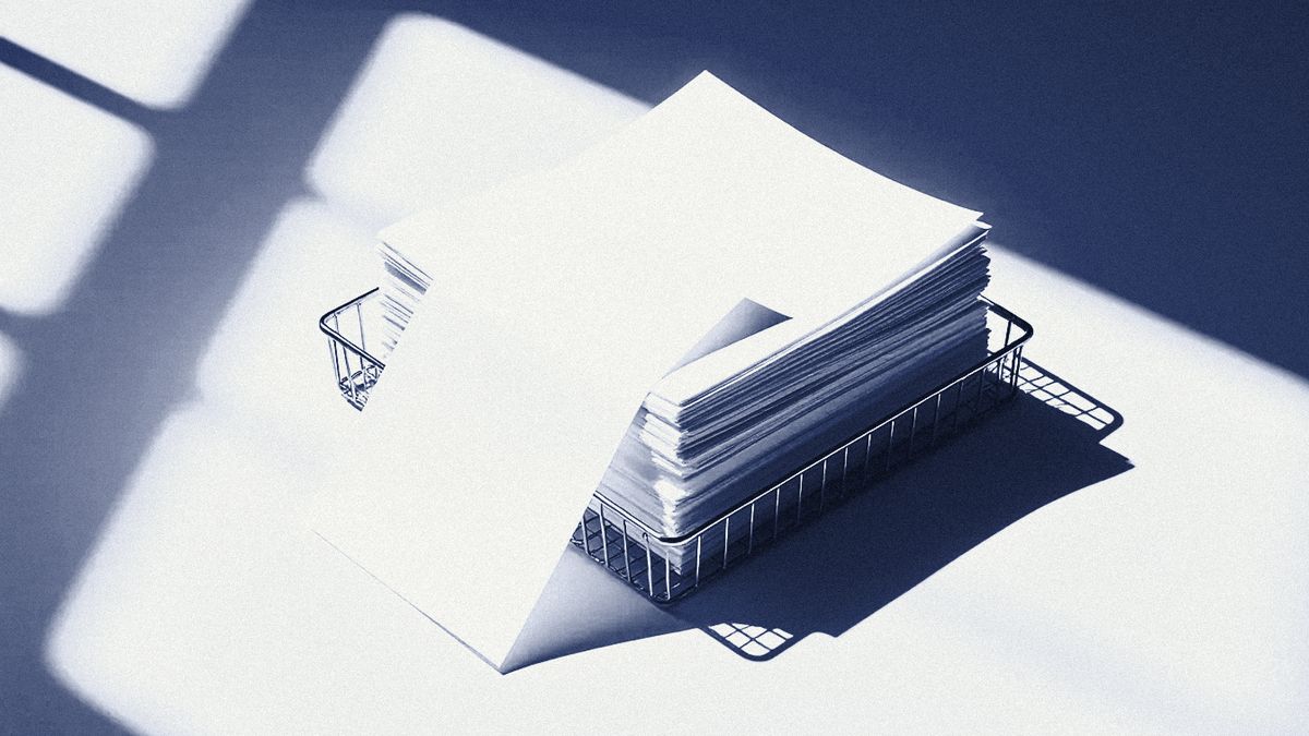 A wire in-tray stacked with paper.